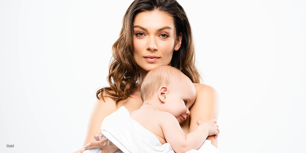 Female holding a baby in her arm on white background